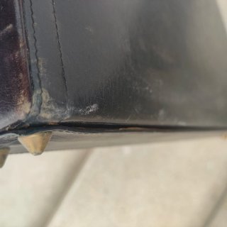 Maletín de piel negro con detalles dorados