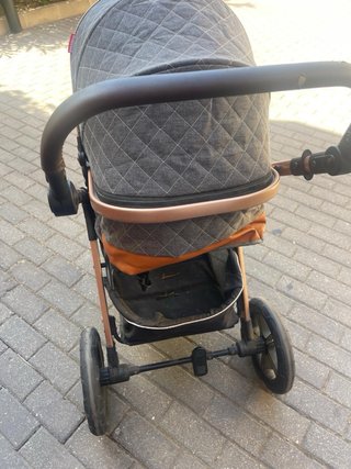 Carrito de bebé gris con detalles en cobre