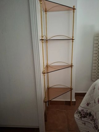 Estantería de rincón dorada y cristal