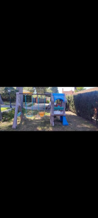 Parque infantil columpios, tobogán y caseta
