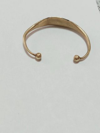 Bracciale rigido dorato con dettagli neri