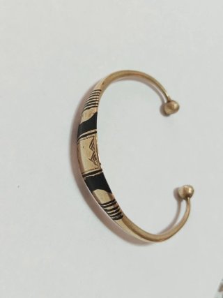 Bracciale rigido dorato con dettagli neri