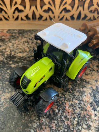 Tractor verde con remolque de troncos