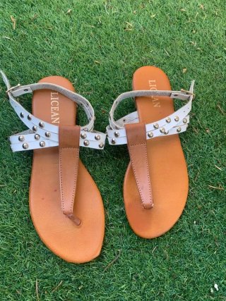 Sandalias planas blancas y marrones con tachuelas