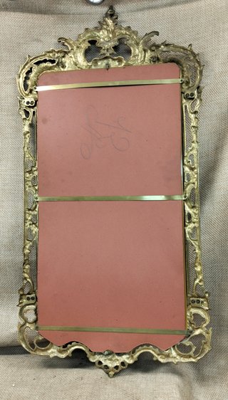 Antiguo espejo de bronce con marco decorado