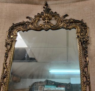 Antiguo espejo de bronce con marco decorado