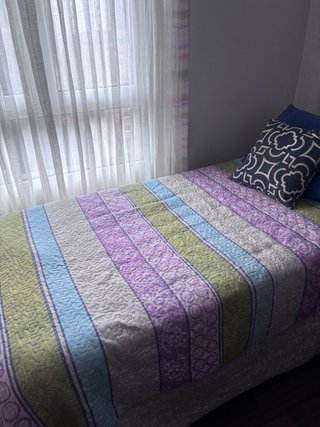 Cama individual con colcha estampada