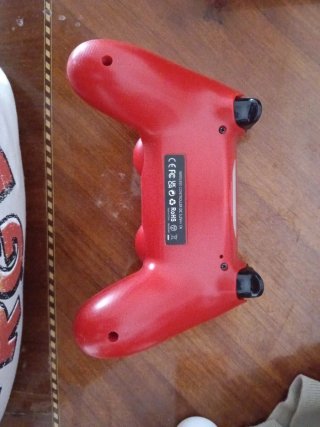 Consola PS4 con mando rojo y disco azul
