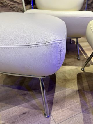 Sillón de diseño en piel blanca y dos puff