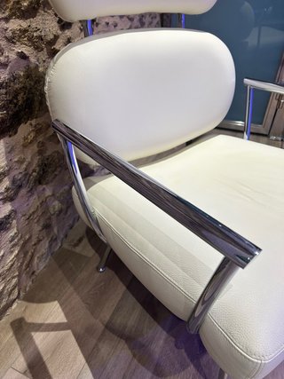 Sillón de diseño en piel blanca y dos puff