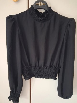 Blusa nera con collo alto e maniche a sbuffo