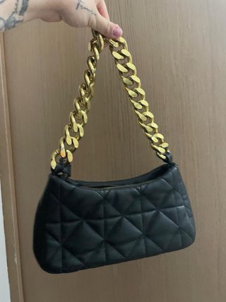 Bolso negro con cadena dorada.