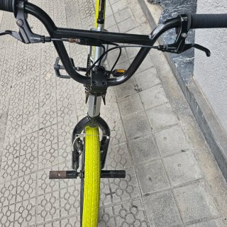 Bicicleta BMX plateada con ruedas verdes