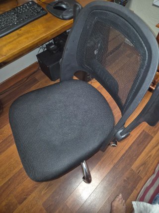 Silla de oficina ergonómica negra regulable.