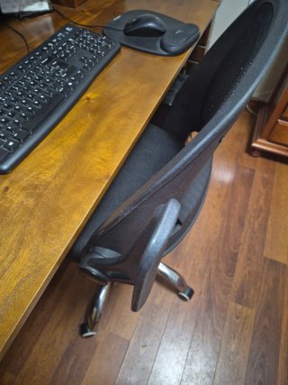 Silla de oficina ergonómica negra regulable.