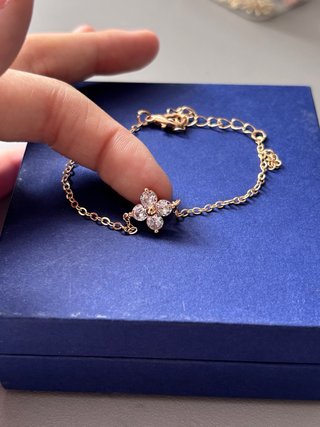 Pulsera dorada con detalle de flor y circonitas