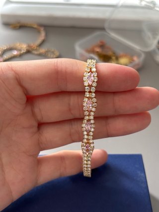 Pulsera dorada con piedras rosas