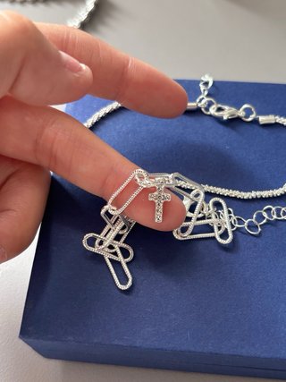 Pulsera plateada con eslabones y cruz