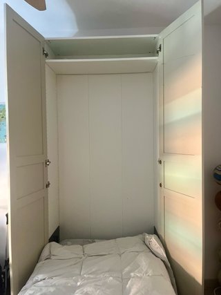 Armario  cama plegable puertas beige y blanco.