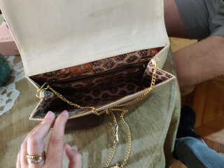 Bolso de mano beige con detalles dorados