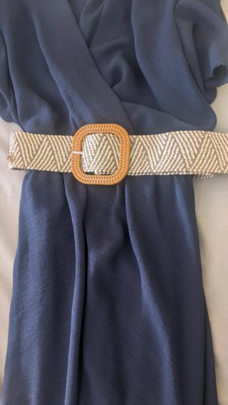Vestido veraniego azul con cinturón beige.
