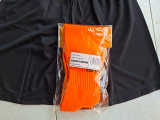 Kit calcio arancione e nero con etichetta.
