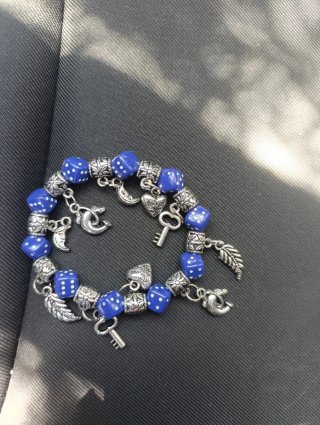 Pulsera con dados azules y dijes plateados