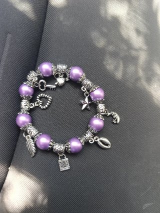 Pulsera con dijes de plata y perlas moradas