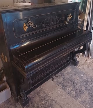 Piano antiguo negro con adornos dorados
