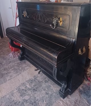Piano antiguo negro con adornos dorados