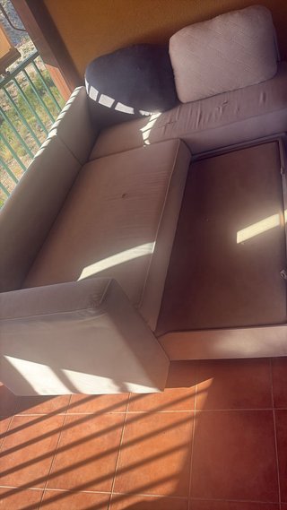 Sofá modular beige con mesa de cristal y cama