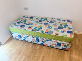 Sofá modular beige con mesa de cristal y cama