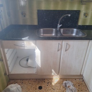 Cocina modular beige y negra con mármol.