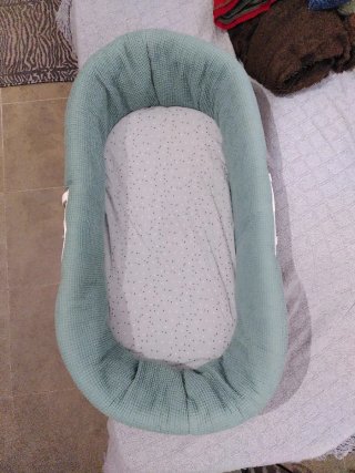Moisés de mimbre con fund verde.