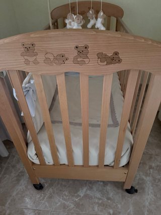 Cuna de madera con móvil de ositos