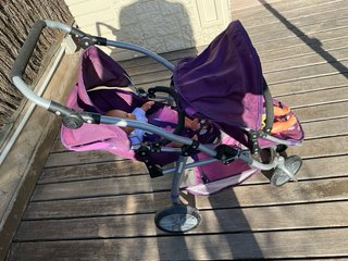Carrito gemelar morado con 2 muñecas