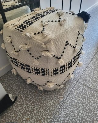 Puf de tela beige y negro con flecos