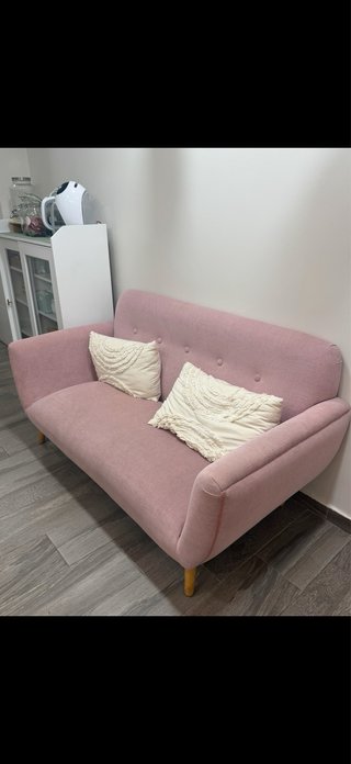 Sofá rosa de tela con cojines