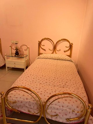 Cama dorada con mesita de noche