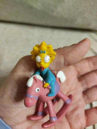 Figura Maggie Simpson en caballito balancín