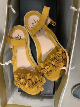 Sandalias amarillas verano con flores. Mudanza