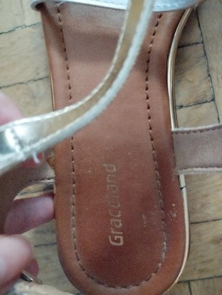 Sandalias planas plateadas y blancas de mujer.