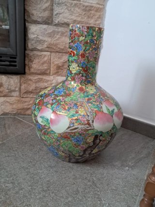 Jarrón de porcelana con flores y melocotones