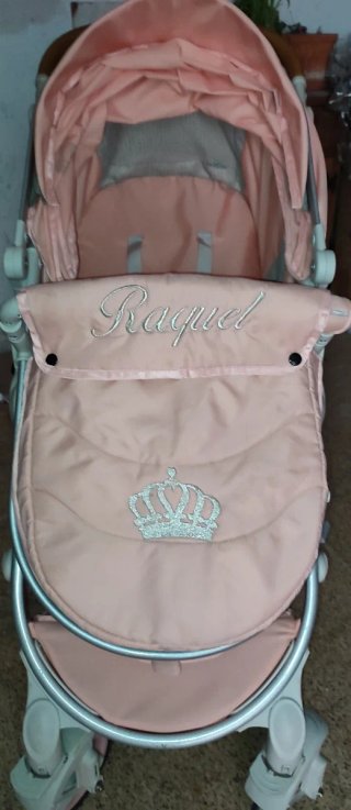 Carrito de bebé rosa con corona