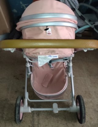 Carrito de bebé rosa con corona