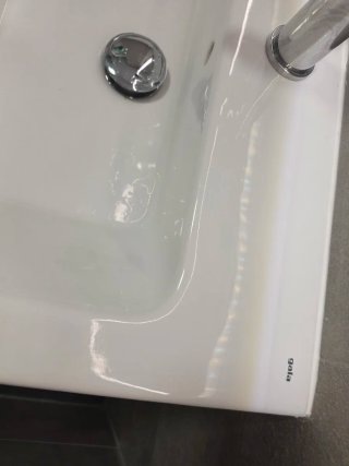 Lavabo de cerámica blanco con grifo.