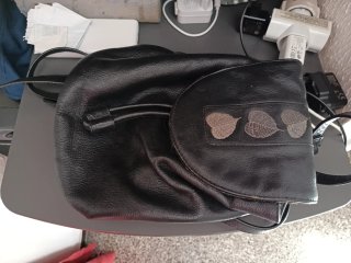 Mochila de piel negra con hojas bordadas