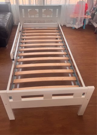 Cama infantil blanca con ovejas.