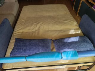 Sofá cama con lamas de madera y estructura tubular