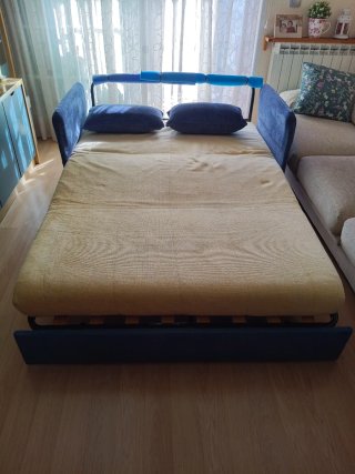 Sofá cama con lamas de madera y estructura tubular